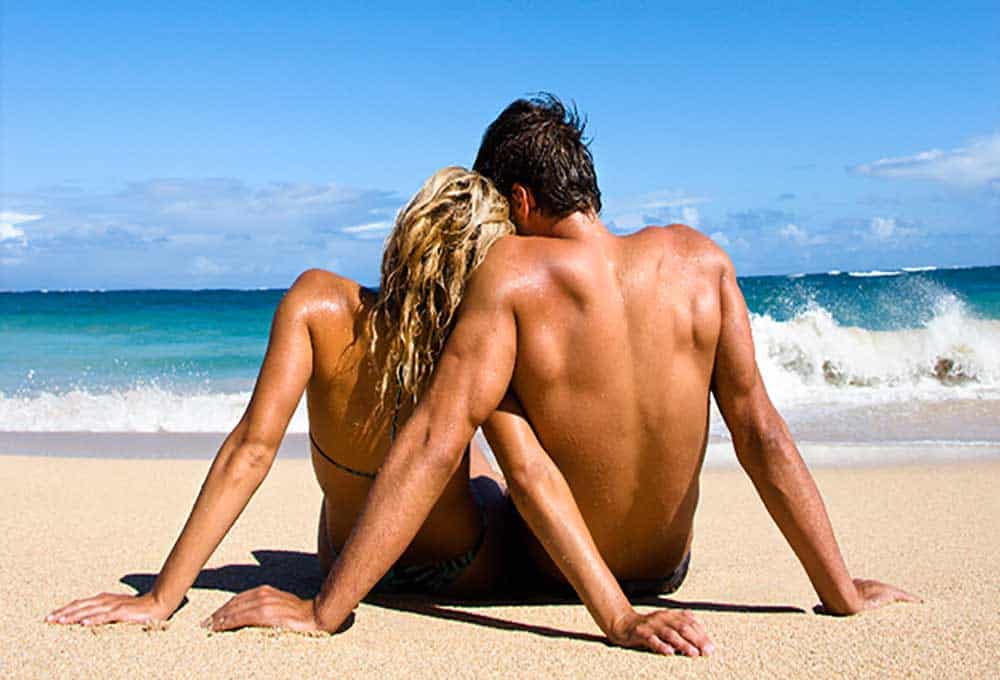 Honeymooning couple on a beach.