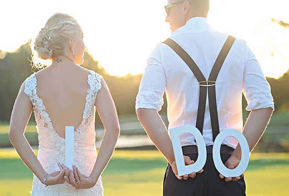 Bride and groom with "I DO" letters.