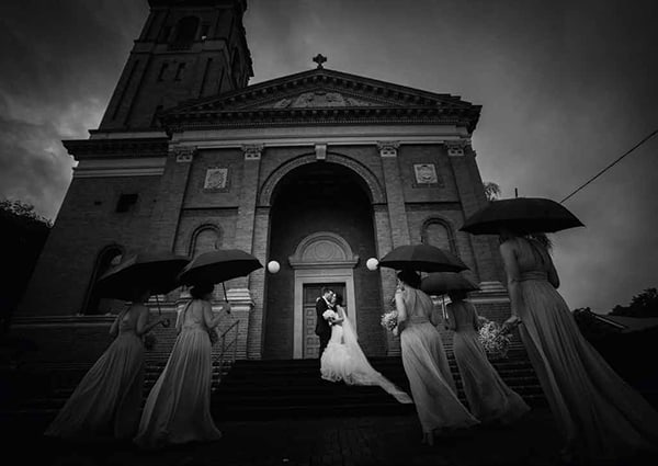 Bride and groom on the stairs of the church in black and white by Porfyri Photography
